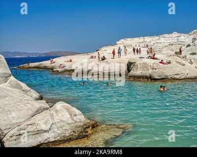 Eine Landschaftsansicht der Menschen auf den felsigen Klippen am Sarakiniko Strand, Insel Milos, Kykladen, Griechenland Stockfoto