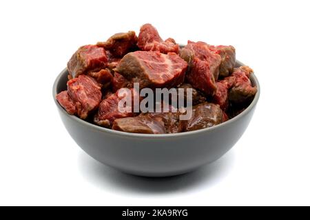 Schüssel rohes rotes Fleisch in Würfel isoliert auf weißem Hintergrund Stockfoto