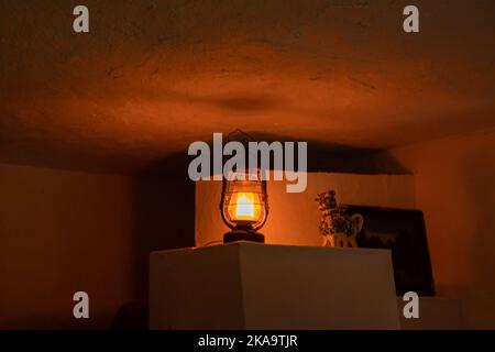 Eine Petroleumlampe steht in einem ländlichen Haus auf einem Herd in der Ukraine, Weihe in einem Haus in einem Dorf ohne Licht Stockfoto