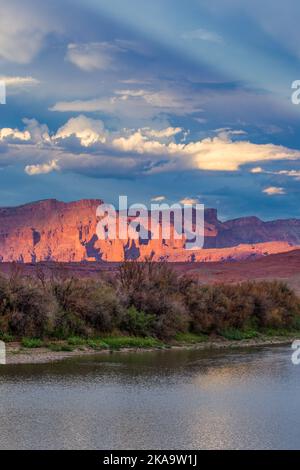 Ein antirepuskulärer Strahl über Fisher Towers & Waring Mesa und dem Colorado River, von der Red Cliffs Ranch bei Sonnenuntergang. Moab, Utah. Stockfoto