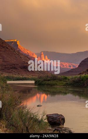 Sturmwolken und Abendlicht auf den Fisher Towers über dem Colorado River in der Nähe von Moab, Utah. Stockfoto