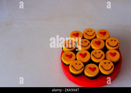 Kleine Kuchen auf dem Teller mit Smiley und Herd zum Feiern Stockfoto