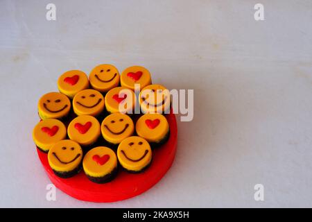 Kleine Kuchen auf dem Teller mit Smiley und Herd zum Feiern Stockfoto