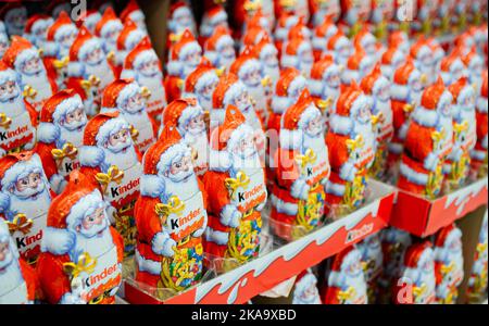 Moskau, Russland, November 2020: Viele Schokoladen-Weihnachtsklauseln von Kinder im knalligen orange-roten Outfit mit Logo. Stockfoto