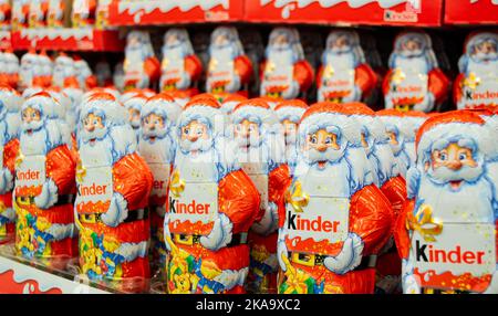 Moskau, Russland, November 2020: Viele Schokoladen-Weihnachtsklauseln von Kinder im knalligen orange-roten Outfit mit Logo. Stockfoto