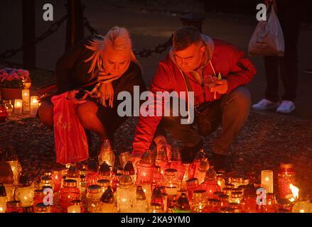 Am 01. November 2022 werden Menschen auf dem Brodno-Friedhof in Warschau, Polen, Kerzen anzünden sehen. Stockfoto