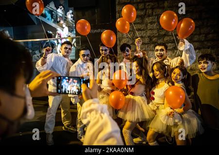 Hongkong, China. 29. Oktober 2022. Ein Mann fotografiert seine Freunde, die sich während der Feier in Lan Kwai Fong als Clowns verkleiden. Trotz der Politik der sozialen Distanz und des obligatorischen Maskengesetzes, das in der Stadt nach der Null-Covid-19-Politik in China immer noch wirksam ist, feiern Menschen in verschiedenen Kostümen Halloween. (Foto von Alex Chan Tsz Yuk/SOPA Images/Sipa USA) Quelle: SIPA USA/Alamy Live News Stockfoto