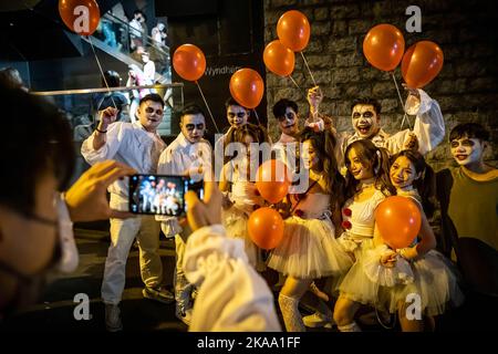 Hongkong, China. 29. Oktober 2022. Ein Mann fotografiert seine Freunde, die sich während der Feier in Lan Kwai Fong als Clowns verkleiden. Trotz der Politik der sozialen Distanz und des obligatorischen Maskengesetzes, das in der Stadt nach der Null-Covid-19-Politik in China immer noch wirksam ist, feiern Menschen in verschiedenen Kostümen Halloween. (Bild: © Alex Chan Tsz Yuk/SOPA Images via ZUMA Press Wire) Stockfoto