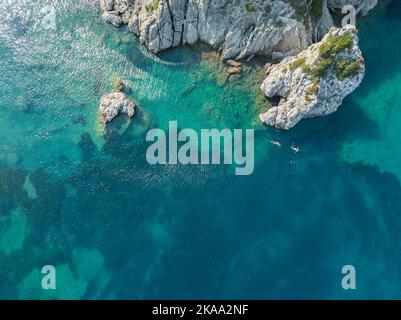 Luftaufnahme der Küste in der Nähe von Porto Timoni, Insel Korfu. Griechenland. Badegäste, die in das kristallklare Wasser der griechischen Küste eingetaucht sind Stockfoto