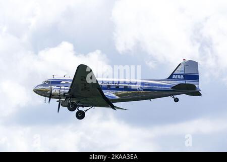 Liepaja, Lettland - 07. August 2022: Altes Douglas DC3-Passagierflugzeug aus Finnland auf dem Flug über dem Flughafen Liepaja, wolkenbedeckter Himmel Stockfoto