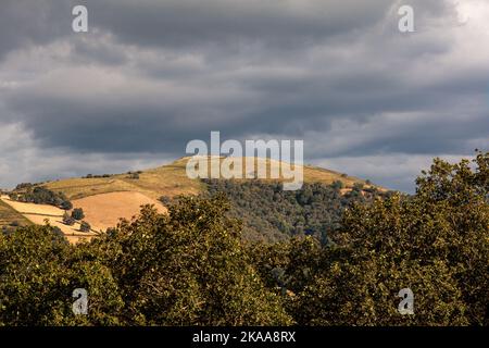 Blick von oben auf die französischen Hügel am wolkigen Himmel. Naturlandschaft entlang des Chemin du Puy. Jakobsweg Stockfoto