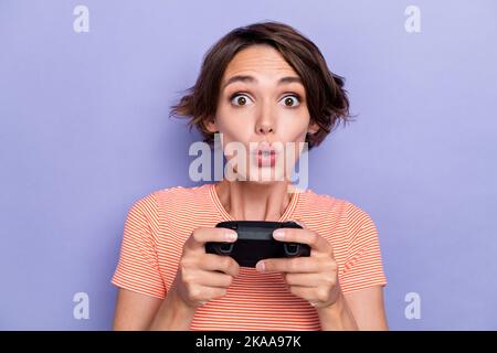 Nahaufnahme Foto von staunenden Dame großen Augen Spaß haben playstation Zeitvertreib Freizeit isoliert auf lila Hintergrund. Stockfoto