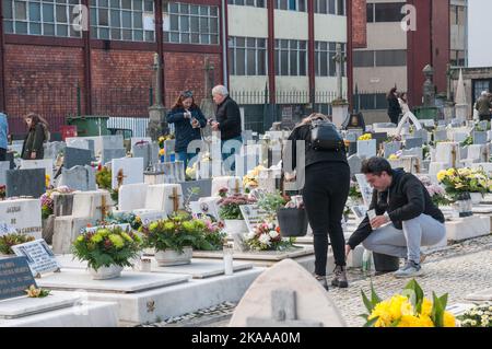 Porto, Portugal. 01.. November 2022. Ein Paar reinigt den Grabstein ihrer Familie und setzt eine Kerze. Im November 1. erinnern sich die Familien an ihre verstorbenen Angehörigen. Eine Tradition, die seit Hunderten von Jahren besteht. Papst Gregor III. Hat im 7.. Jahrhundert allen Heiligen eine Kapelle im Petersdom geweiht. Es war im 9.. Jahrhundert, dass Papst Gregor IV. Dieses Fest für die ganze Kirche. Kredit: SOPA Images Limited/Alamy Live Nachrichten Stockfoto