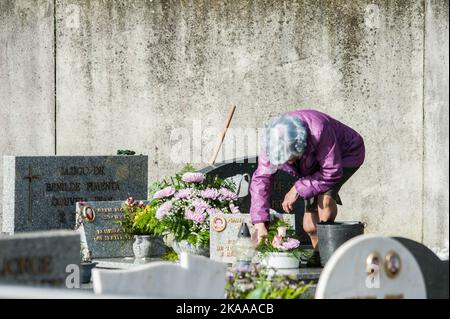 Porto, Portugal. 01.. November 2022. Eine Frau reinigt den Grabstein während Allerheiligen. Im November 1. erinnern sich die Familien an ihre verstorbenen Angehörigen. Eine Tradition, die seit Hunderten von Jahren besteht. Papst Gregor III. Hat im 7.. Jahrhundert allen Heiligen eine Kapelle im Petersdom geweiht. Es war im 9.. Jahrhundert, dass Papst Gregor IV. Dieses Fest für die ganze Kirche. (Foto: Mario Coll/SOPA Images/Sipa USA) Quelle: SIPA USA/Alamy Live News Stockfoto