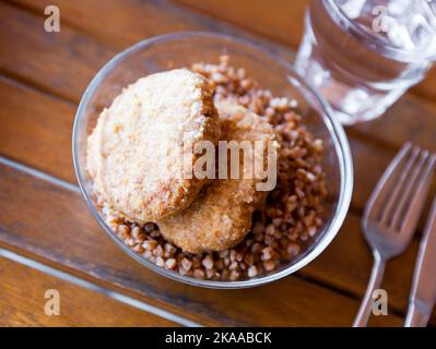 Gekochter Buchweizen mit Fleischschnitzel auf dem Tisch Stockfoto