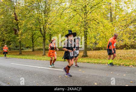 Läuferin in einem Hexe-Kleid im Worksop Halloween Halbmarathon. Stockfoto