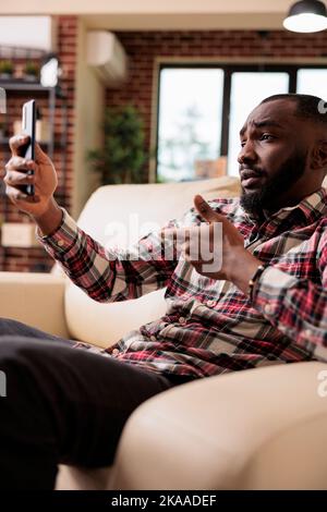 Erwachsene, die an einer Online-Videocall-Konferenz teilnehmen und mit einer Smartphone-App mit Personen in einer Videokonferenz sprechen. Freiberuflicher Chat bei Remote-Telefonkonferenzen über ein Mobiltelefon. Stockfoto