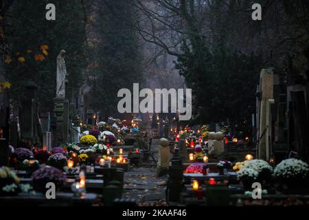 Warschau, Polen. 01.. November 2022. Eine Reihe von Gräbern bedeckt mit brennenden Kerzen und Blumen, die am Allerheiligen-Tag auf dem Pow?zki Friedhof gesehen wurden. Allerheiligen/Allerseelen (oder Dzie? Zaduszny auf Polnisch) ist ein Feiertag und eine Gelegenheit, an die Toten zu erinnern. An diesem Tag bringen Menschen Blumen und Kerzen auf Friedhofs. In der Dunkelheit ist der Friedhof voller Lichter. Der POW?zki Friedhof (oder Old Pow?zki) ist eine historische Nekropole in Warschau. Es ist der berühmteste Friedhof der Stadt und einer der ältesten. Kredit: SOPA Images Limited/Alamy Live Nachrichten Stockfoto