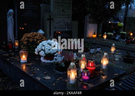 Warschau, Polen. 01.. November 2022. Kerzen bedecken die Gräber am Allerheiligen-Tag auf dem Pow?zki Friedhof. Allerheiligen/Allerseelen (oder Dzie? Zaduszny auf Polnisch) ist ein Feiertag und eine Gelegenheit, an die Toten zu erinnern. An diesem Tag bringen Menschen Blumen und Kerzen auf Friedhofs. In der Dunkelheit ist der Friedhof voller Lichter. Der POW?zki Friedhof (oder Old Pow?zki) ist eine historische Nekropole in Warschau. Es ist der berühmteste Friedhof der Stadt und einer der ältesten. Kredit: SOPA Images Limited/Alamy Live Nachrichten Stockfoto