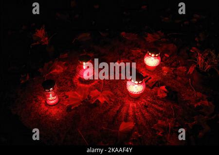 Warschau, Polen. 01.. November 2022. Kerzen und Blätter sind an einem Grab am Allerheiligen-Tag auf dem Pow?zki Friedhof zu sehen. Allerheiligen/Allerseelen (oder Dzie? Zaduszny auf Polnisch) ist ein Feiertag und eine Gelegenheit, an die Toten zu erinnern. An diesem Tag bringen Menschen Blumen und Kerzen auf Friedhofs. In der Dunkelheit ist der Friedhof voller Lichter. Der POW?zki Friedhof (oder Old Pow?zki) ist eine historische Nekropole in Warschau. Es ist der berühmteste Friedhof der Stadt und einer der ältesten. Kredit: SOPA Images Limited/Alamy Live Nachrichten Stockfoto