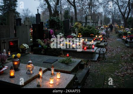 Warschau, Polen. 01.. November 2022. Brennende Kerzen bedecken die Gräber am Allerheiligen-Tag auf dem Pow?zki Friedhof. Allerheiligen/Allerseelen (oder Dzie? Zaduszny auf Polnisch) ist ein Feiertag und eine Gelegenheit, an die Toten zu erinnern. An diesem Tag bringen Menschen Blumen und Kerzen auf Friedhofs. In der Dunkelheit ist der Friedhof voller Lichter. Der POW?zki Friedhof (oder Old Pow?zki) ist eine historische Nekropole in Warschau. Es ist der berühmteste Friedhof der Stadt und einer der ältesten. Kredit: SOPA Images Limited/Alamy Live Nachrichten Stockfoto