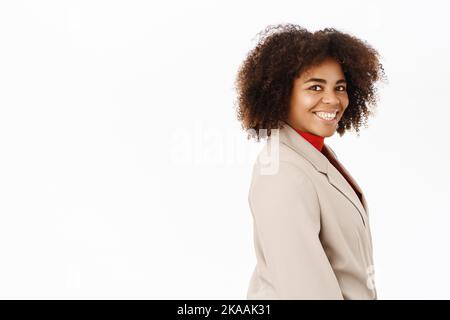 Porträt einer lächelnden afroamerikanischen Geschäftsfrau, einem Angestellten im Anzug, halb gedreht stehend, professionell aussehend, auf weißem Hintergrund stehend Stockfoto
