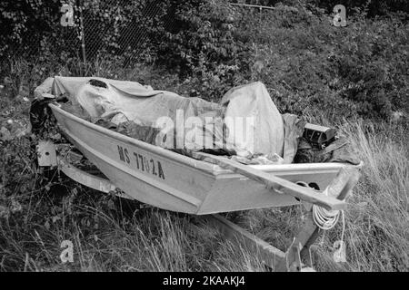 Ein verlassene Aluminium-Fischerboot in einem Anhänger versteckt in das überwuchert Gras in Rockport, Massachusetts. Das Bild wurde mit analogem Schwarz-und-Bild aufgenommen Stockfoto