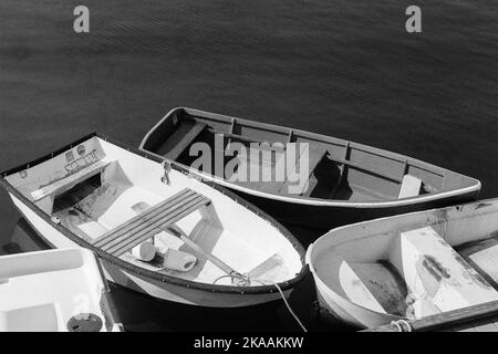 Drei hölzerne Ruderboote, die an Rockport, Massachusetts, angedockt sind. Das Bild wurde auf analogem Schwarzweiß-Film aufgenommen. Stockfoto