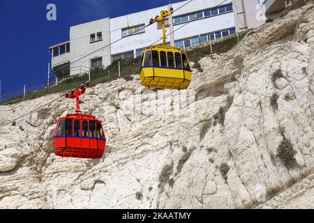 Kabinenbahnen, die zur Standstation der Seilbahn hochfahren Stockfoto