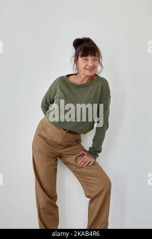 Entzückte Frau mittleren Alters in trendigen Kleidern Stockfoto