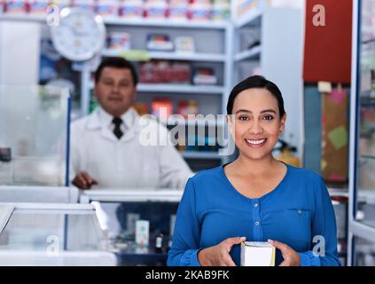 Ich habe meine Medikamente bekommen, jetzt, um besser zu werden. Ein männlicher Apotheker und ein weiblicher Kunde in einer Apotheke. Stockfoto