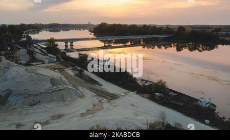 Sonnenuntergang über einer Brücke im Fluss im Herbst Stockfoto