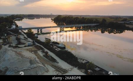 Sonnenuntergang über einer Brücke im Fluss im Herbst Stockfoto