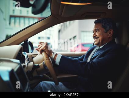 Ein reifer Geschäftsmann, der ein stilvolles Auto fährt. Stockfoto