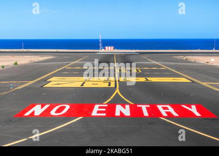 Kein Einstiegsschild an der Start- und Landebahn des Flughafens mit Meer im Hintergrund Stockfoto