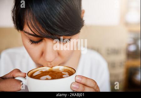 Fünf davon werde ich an einem Tag haben. Nahaufnahme einer schönen jungen Frau, die tagsüber einen Schluck ihres Kaffees in einem Café gekauft hat. Stockfoto