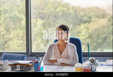 Sie hat ihren Traumberuf. Junge Lehrerin in einem Klassenzimmer. Stockfoto