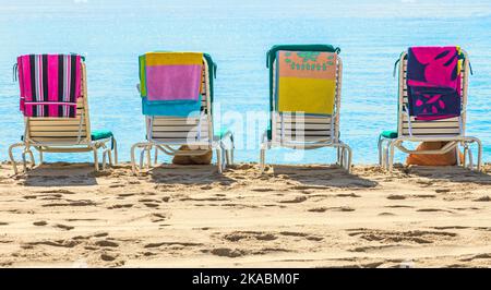 Eine Reihe von drei Strandliegen mit Blick auf das Meer Stockfoto