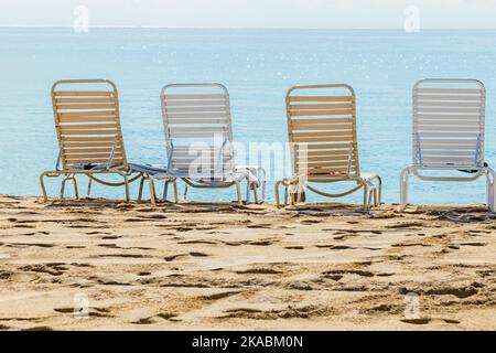 Eine Reihe von drei Strandliegen mit Blick auf das Meer Stockfoto