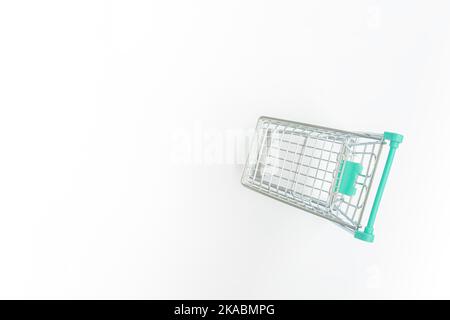 Leerer Einkaufswagen auf weißem Hintergrund. Stockfoto