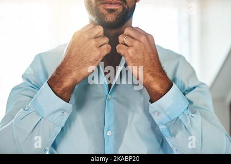 Dieses Hemd macht mich heiß und schweißtreibend. Ein unkenntlich verschwitzter Mann kleidet sich in seinem Schlafzimmer zu Hause. Stockfoto