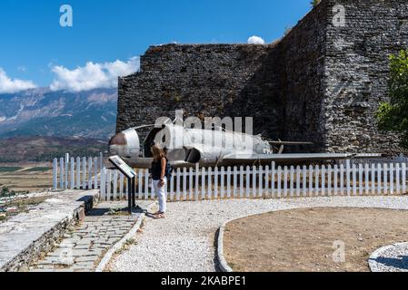 Gjirokaster, Albanien - 10. September 2022: Tourist in der Nähe des amerikanischen Jagdsternflugzeugs Lockheed T-33, ausgestellt auf der Burg Gjirokastra, Albanien Stockfoto