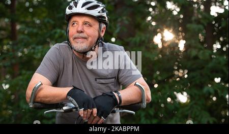 Porträt eines aktiven Senioren mit seinem Fahrrad im Freien, gesundes Lifestyle-Sportkonzept Stockfoto