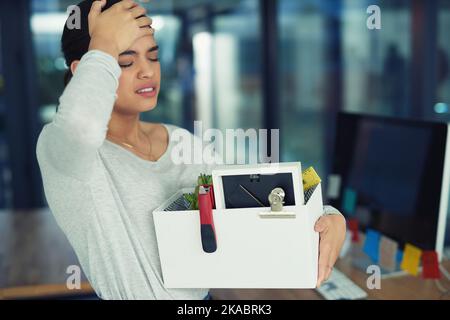 Shes wurde von der Arbeit entlassen. Eine unglückliche Geschäftsfrau hielt ihre Schachtel mit Habseligkeiten, nachdem sie von ihrem Job entlassen wurde. Stockfoto