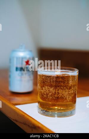 Ein Glas Bier, das von einem indonesischen Bierhersteller mit unscharfem Hintergrund hergestellt wird Stockfoto