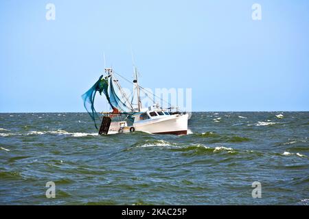 Am späten Nachmittag fährt ein kleines Fischerboot zum Meer Stockfoto