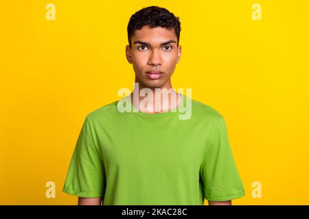 Foto von ruhig fokussierten jungen Mann schauen Kamera Piercing Zubehör isoliert auf gelbem Hintergrund Stockfoto