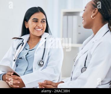 Vielfalt, Gesundheit und Ärzte sprechen im Krankenhaus, haben gelegentliche Gespräche, Diskussionen und Chats. Medizinische Mitarbeiter, Freunde und indische Frau Stockfoto