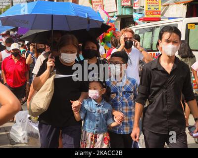 Caloocan City, Philippinen. 01.. November 2022. Eine Familie mit Gesichtsmasken geht zum Friedhof, um ihren Toten während des Allerheiligen-Tages Respekt zu zollen. Filipinos strömen nach zwei Jahren der Covid-19-Pandemie auf Friedhofs, da sich die Einschränkungen langsam lockern. Die Tradition, Blumen zu bringen, Kerzen anzuzünden und sogar Nahrung an der Begräbnisstätte ihrer verstorbenen Lieben anzubieten. Kredit: SOPA Images Limited/Alamy Live Nachrichten Stockfoto