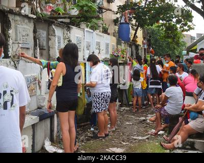 Caloocan City, Philippinen. 01.. November 2022. Filipinos zünden während des Allerheiligen-Tages Kerzen an und respektieren ihre Toten. Filipinos strömen nach zwei Jahren der Covid-19-Pandemie auf Friedhofs, da sich die Einschränkungen langsam lockern. Die Tradition, Blumen zu bringen, Kerzen anzuzünden und sogar Nahrung an der Begräbnisstätte ihrer verstorbenen Lieben anzubieten. Kredit: SOPA Images Limited/Alamy Live Nachrichten Stockfoto